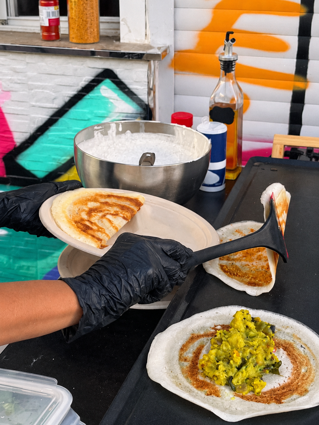 Golden dosas and potato masala being served at the grill