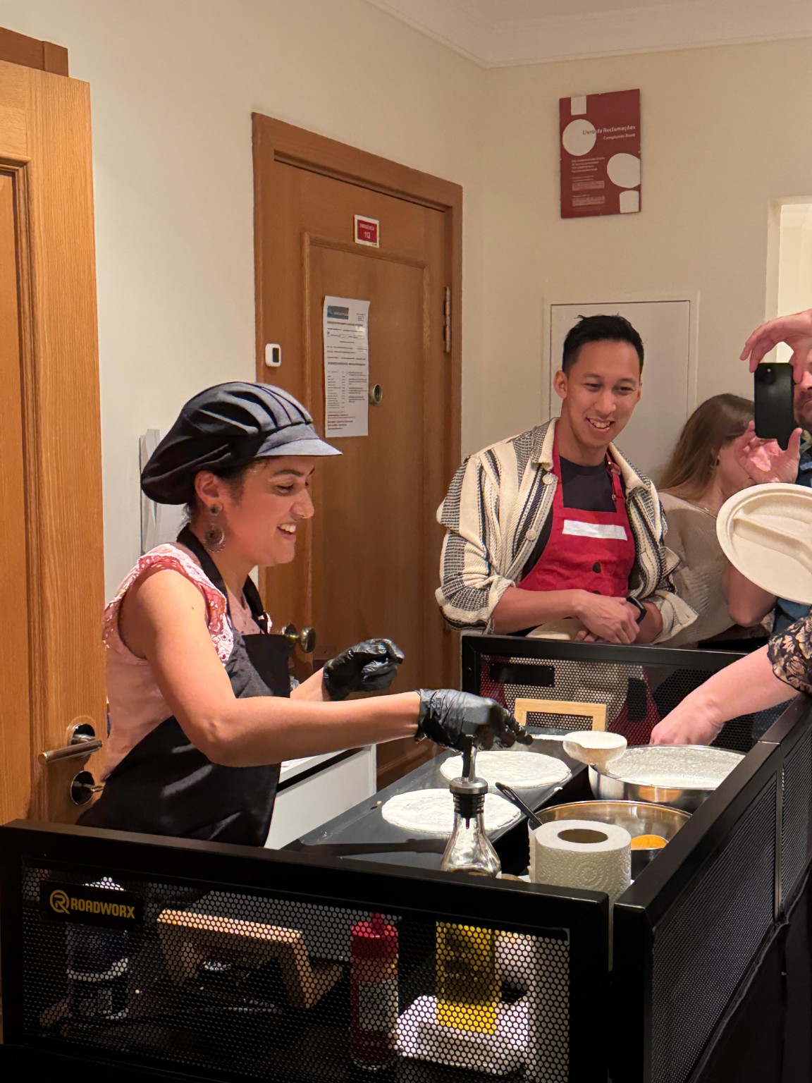 Anitha smiling as guests gather at the indoor dosa station