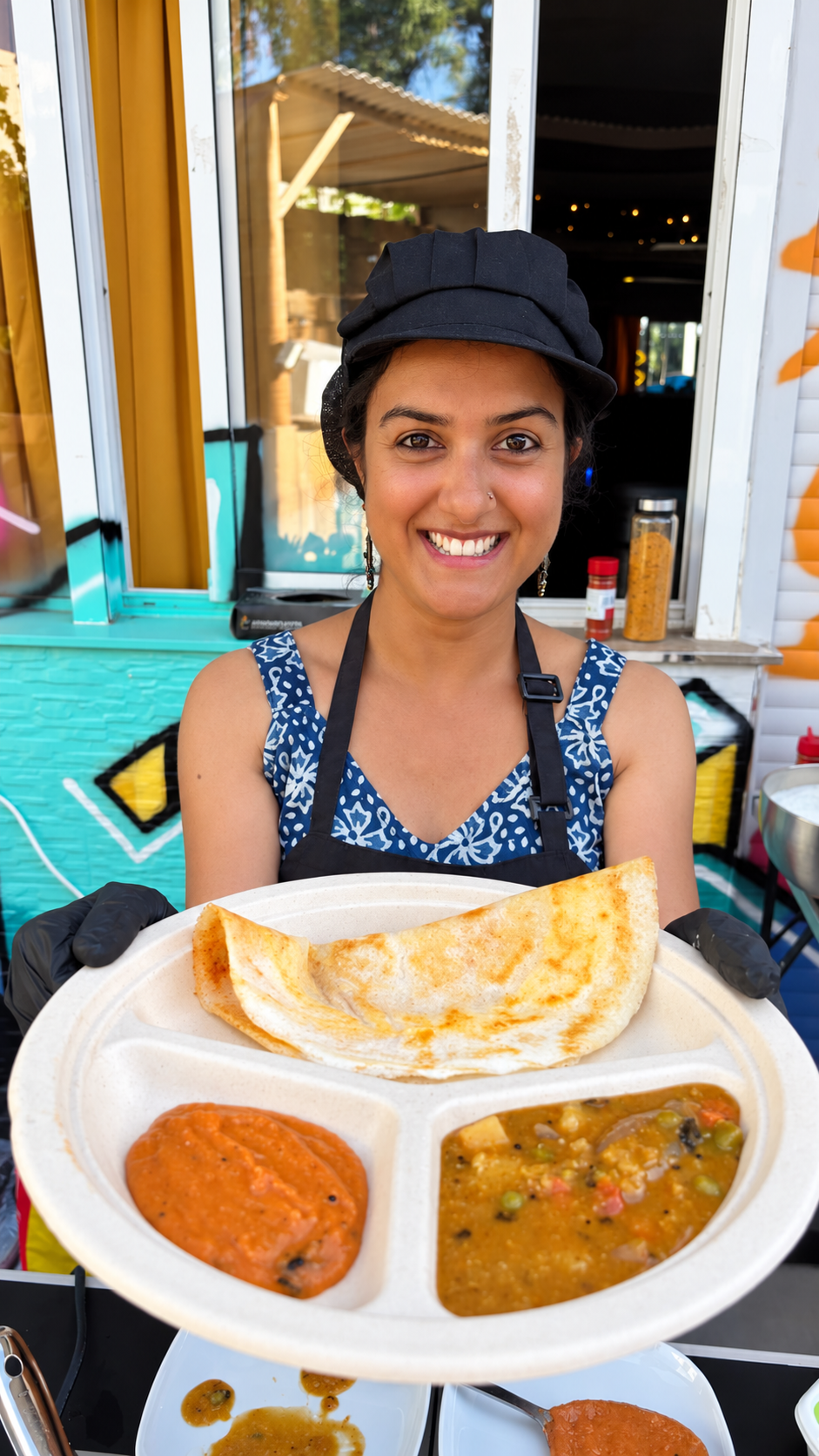 Anitha holding a freshly made dosa with chutney and sambar